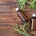 Bottles of rosemary essential oil on table