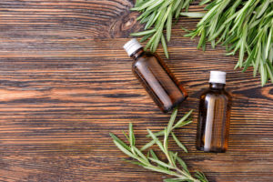 Bottles of rosemary essential oil on table