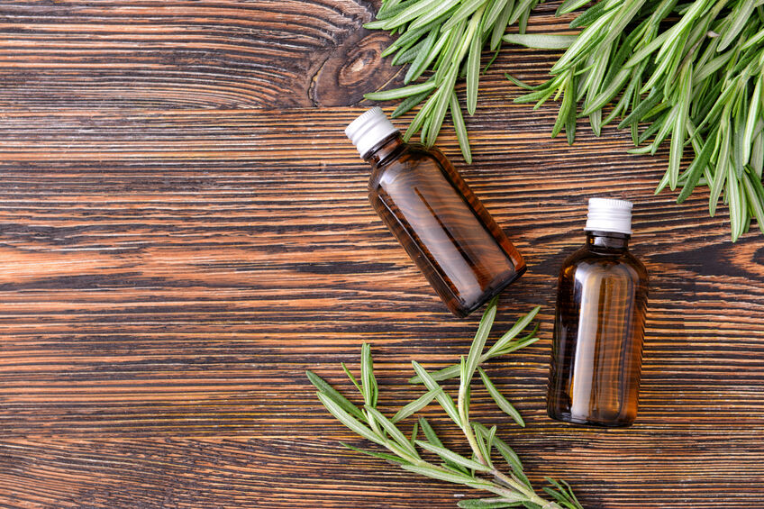 Bottles of rosemary essential oil on table