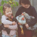 Two girls holding chickens