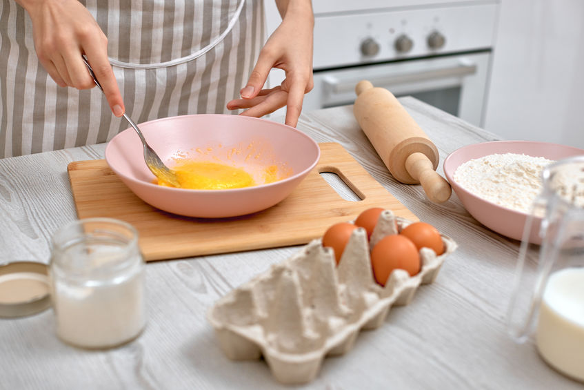 woman beats eggs in kitchen